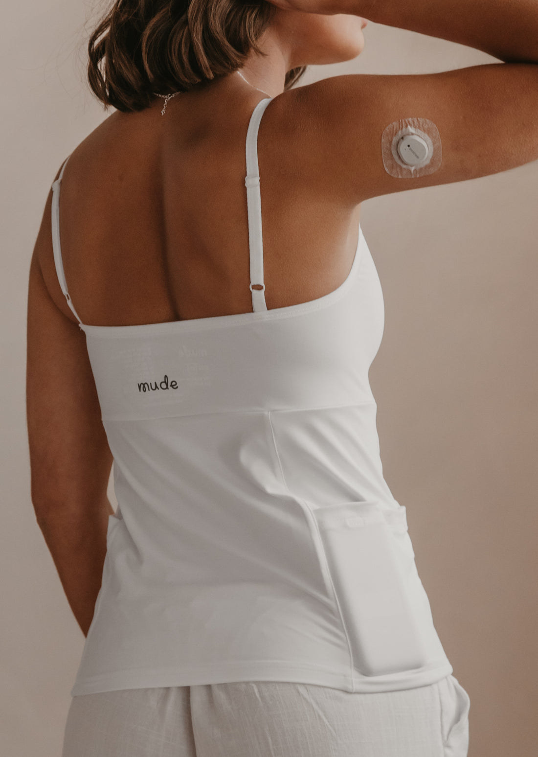 Woman wearing a white Mude Camisole top with &